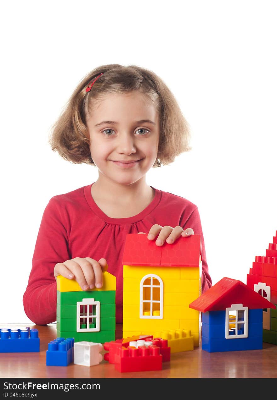 Cute little girl is constructing a house using building blocks