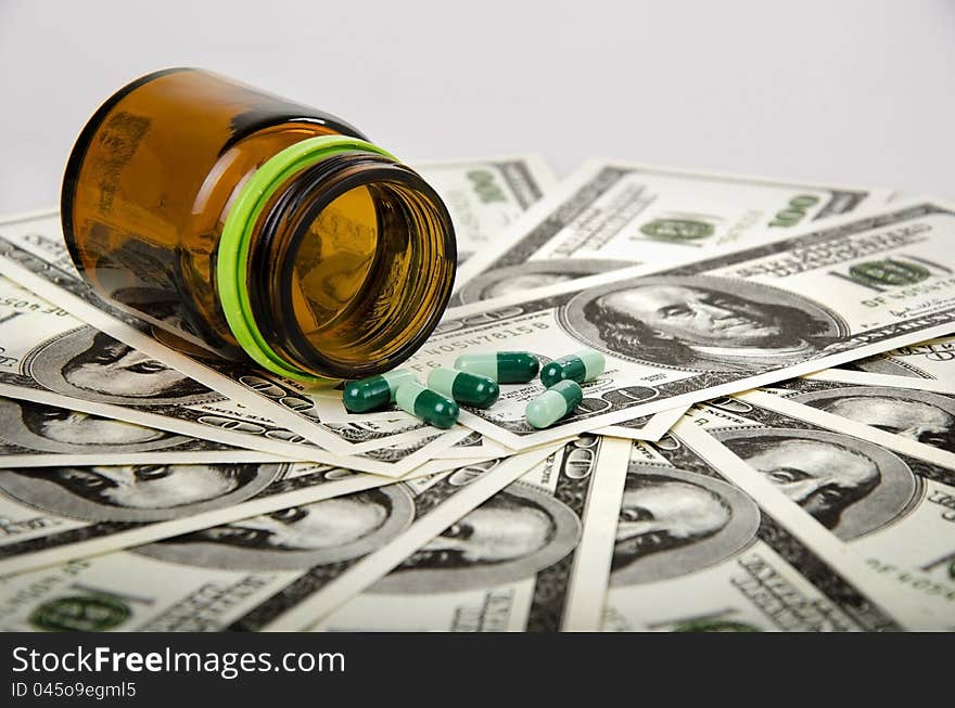 Some medicine and its bottle on dollars. Some medicine and its bottle on dollars