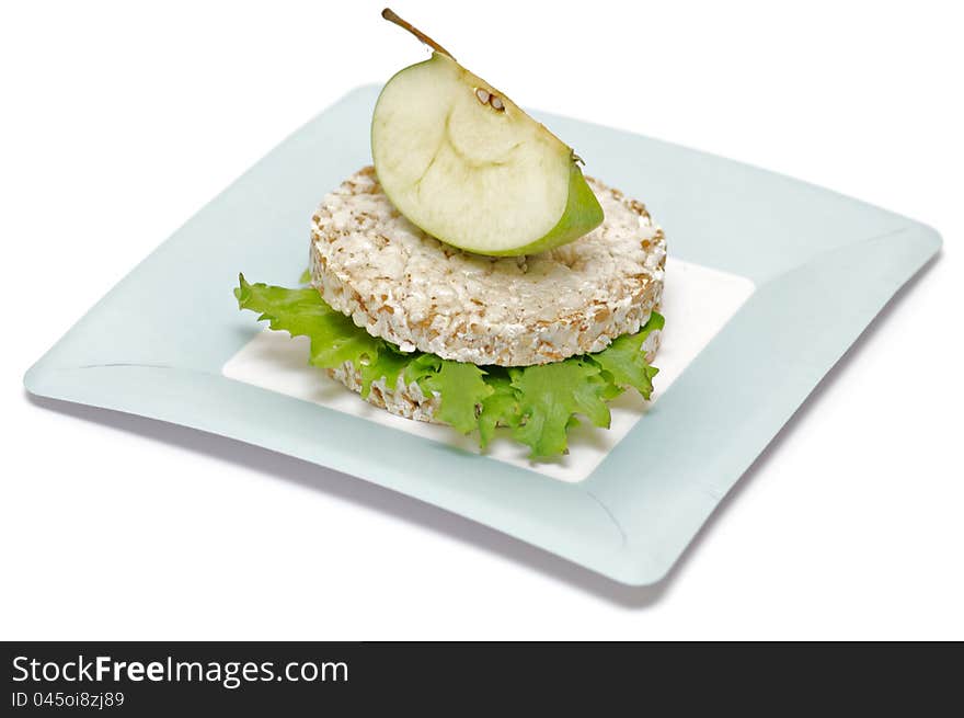 Gramineae Crispbread with Salad leaves and apple isolated on blue plate