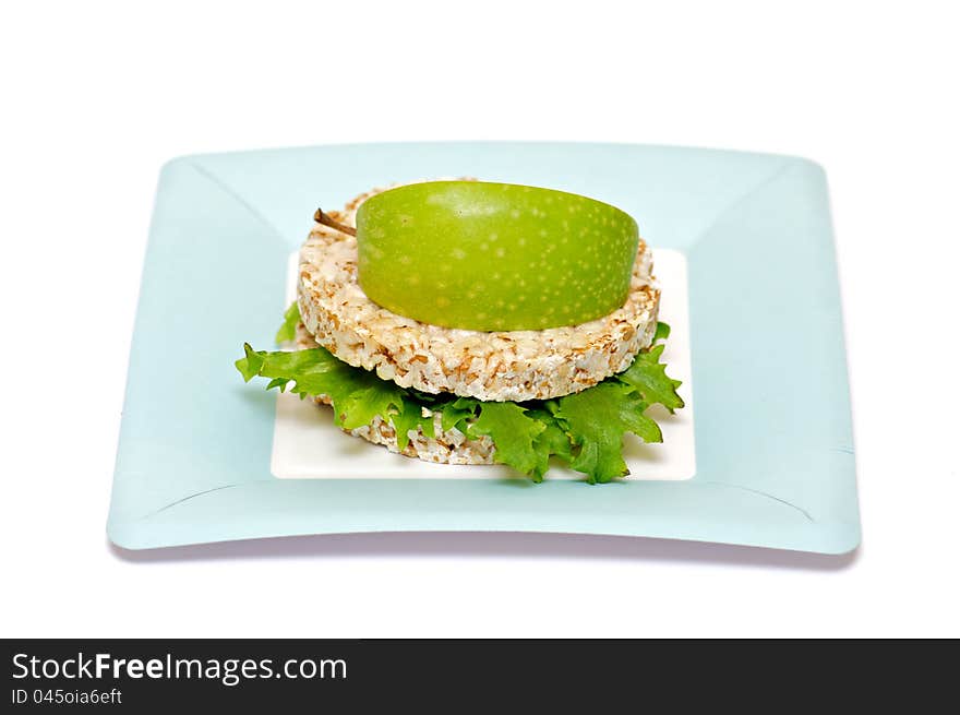 Gramineae Crispbread with Salad leaves and apple isolated on blue plate