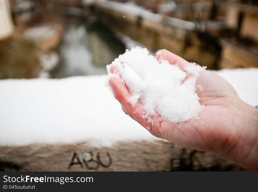 A man holds snow in his hand. A man holds snow in his hand