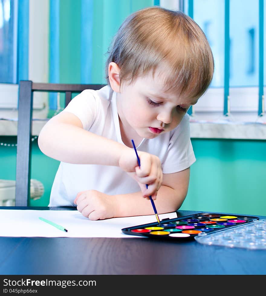 Cute little boy painting with watercolors