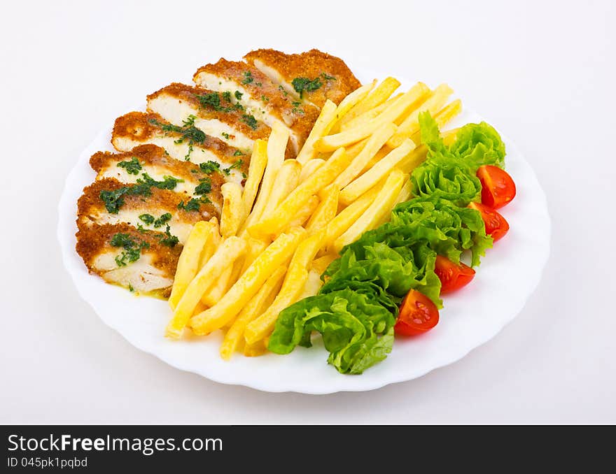 Plate with french fries, chicken breast and salad. Plate with french fries, chicken breast and salad