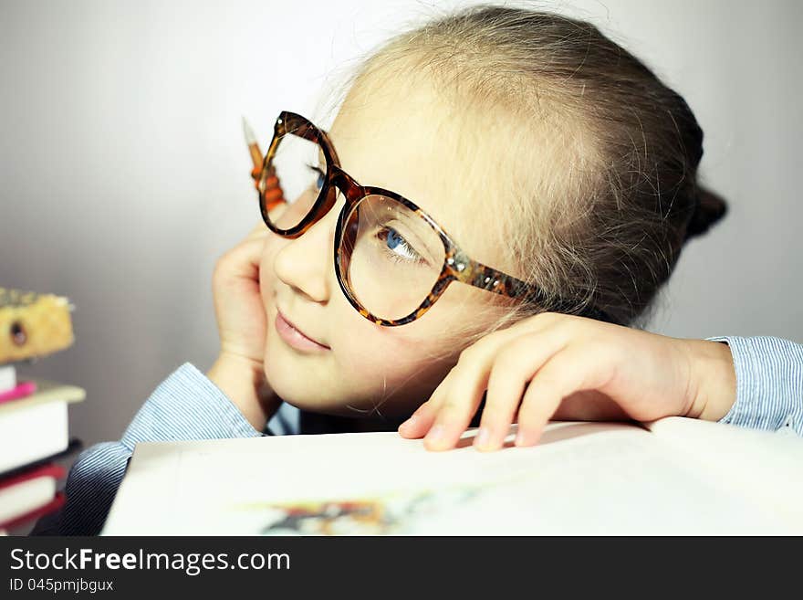 Schoolgirl with big glasses thinking about school. Schoolgirl with big glasses thinking about school