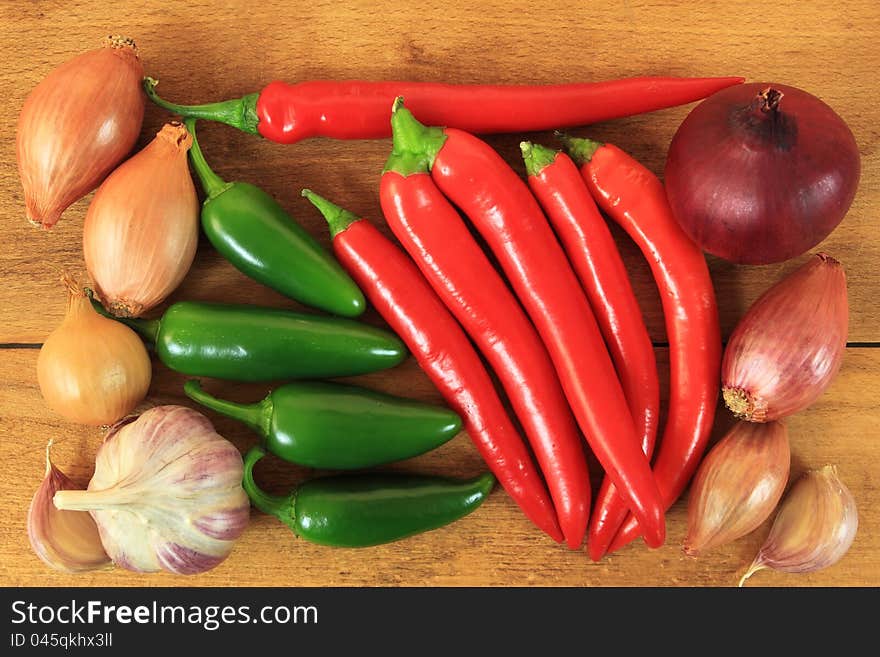 Red and green hot chili peppers on old wooden table. Red and green hot chili peppers on old wooden table.