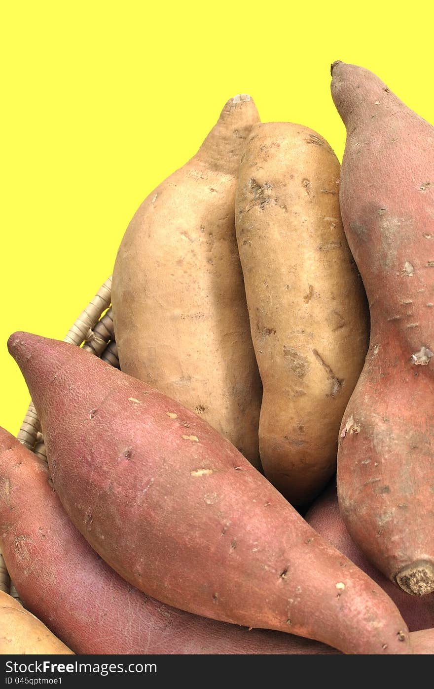 Closeup of red yams and sweet potatoes on yellow