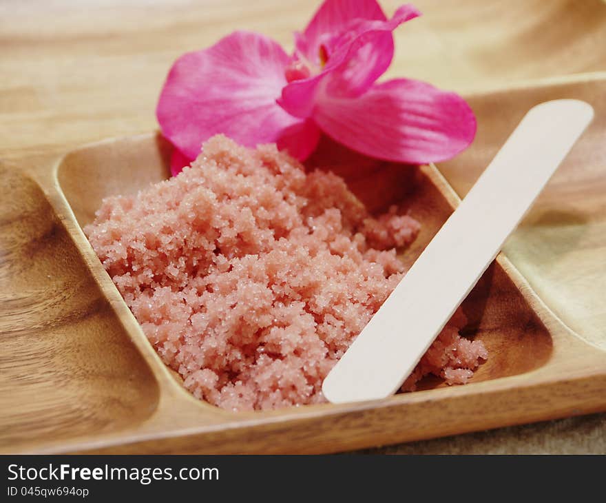 Spa Crystals in wood container with spatula and pink orchid