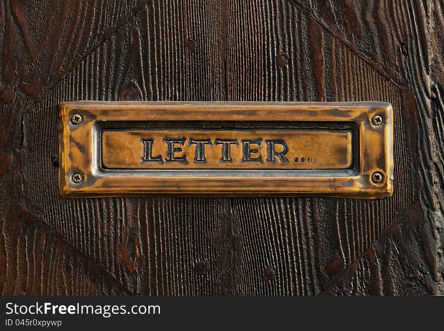 Semi-antique mail box against a door of a dark tree. Semi-antique mail box against a door of a dark tree