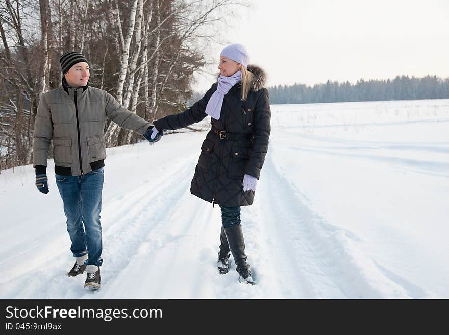 Man and women walk on the winter road. Man and women walk on the winter road