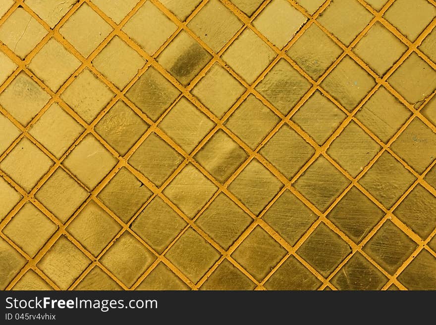 Gold tile mosaic background at an ancient Thai Buddhist temple, Bangkok, Thailand.