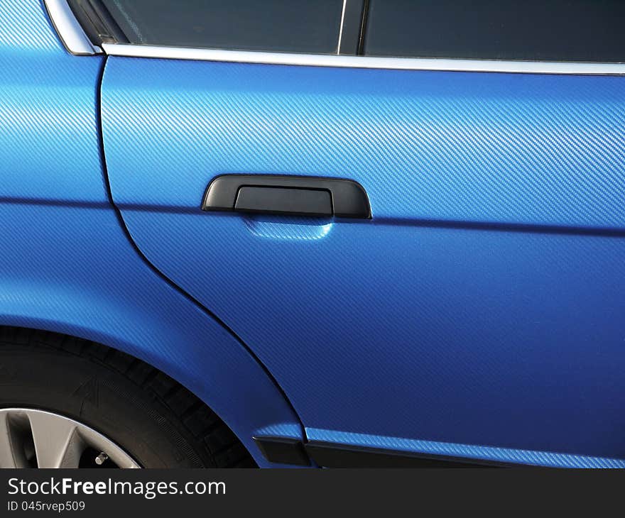 Part of the vehicle body covered with a blue film that simulates the carbon. Part of the vehicle body covered with a blue film that simulates the carbon