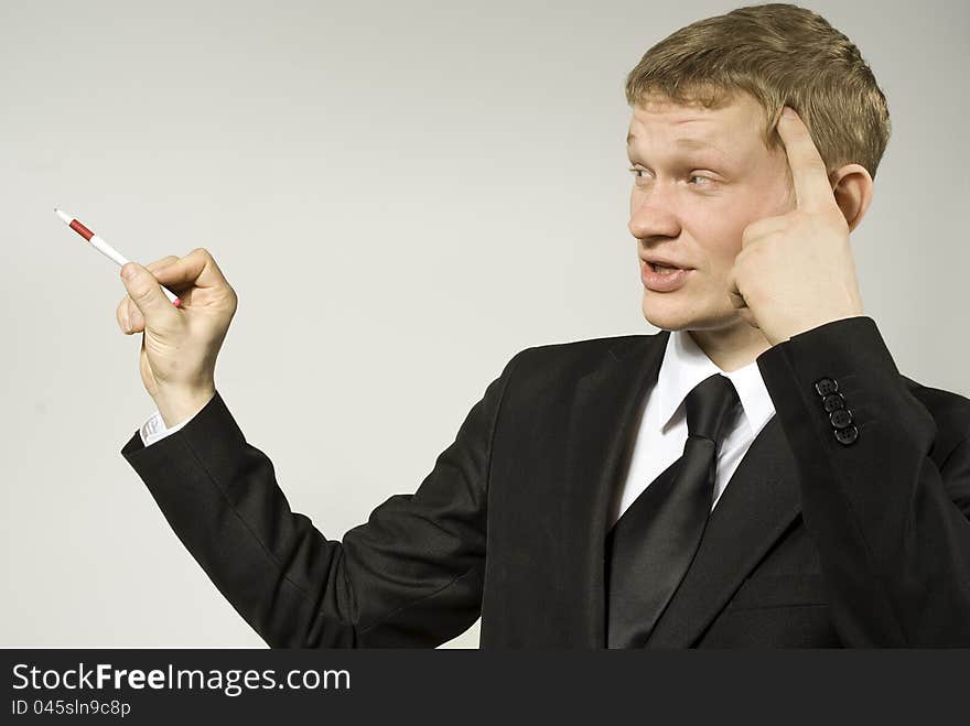 Handsome guy thoughtfully points out a hand to the side on the background. Handsome guy thoughtfully points out a hand to the side on the background