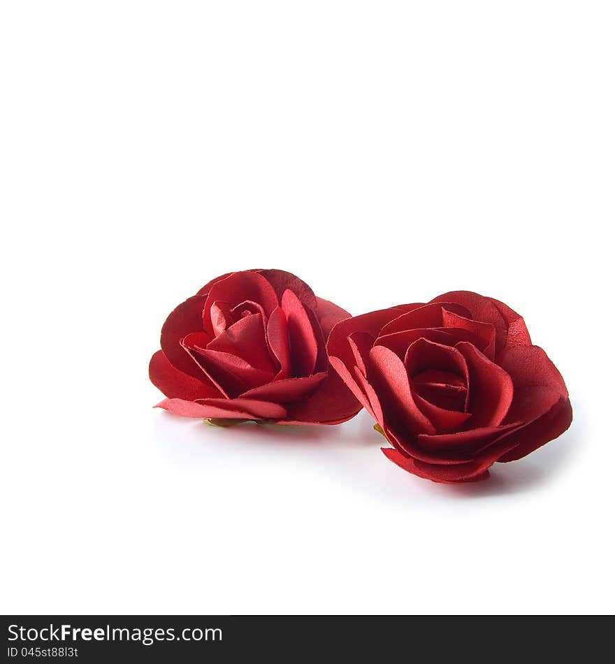 Two red paper roses isolated on a white background. Copy space. Two red paper roses isolated on a white background. Copy space.