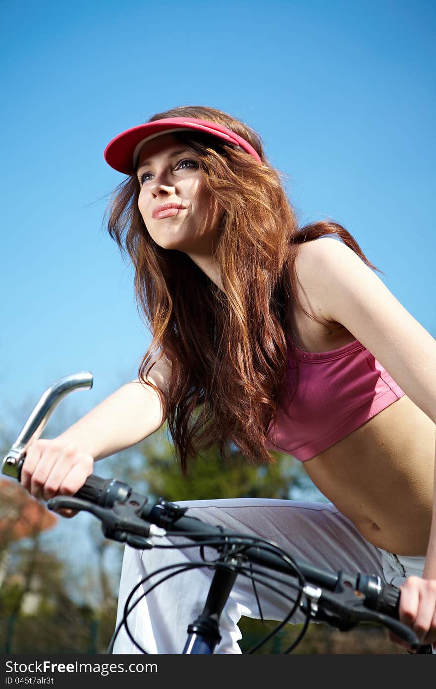 Young woman on a bicykle outdoors smiling