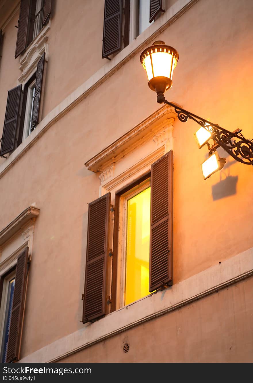 Vintage lantern on the wall near glowing window. Vintage lantern on the wall near glowing window