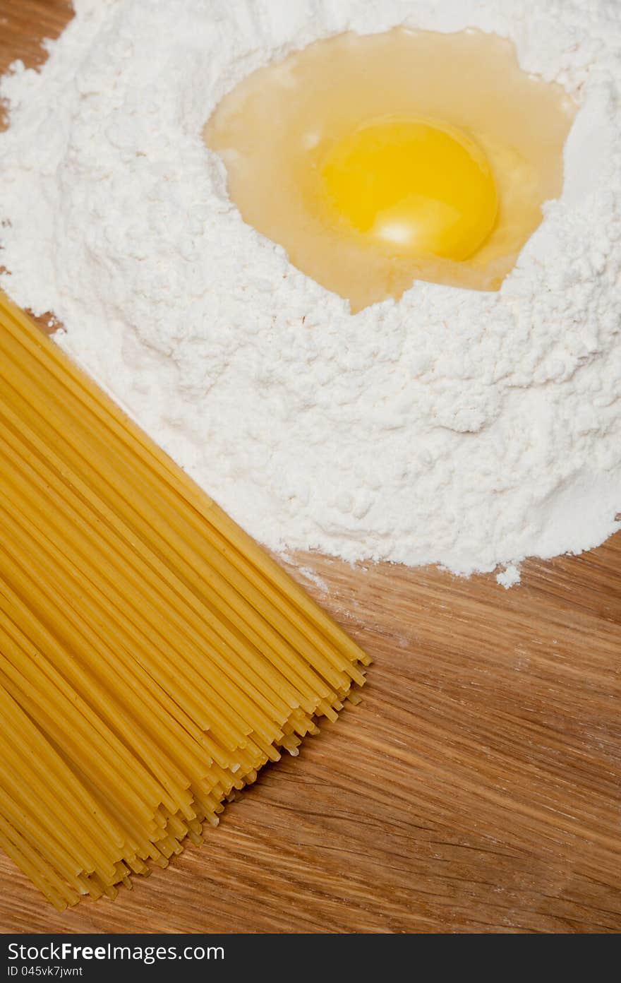 Flour with yolk and macaroni on the wood table. Flour with yolk and macaroni on the wood table