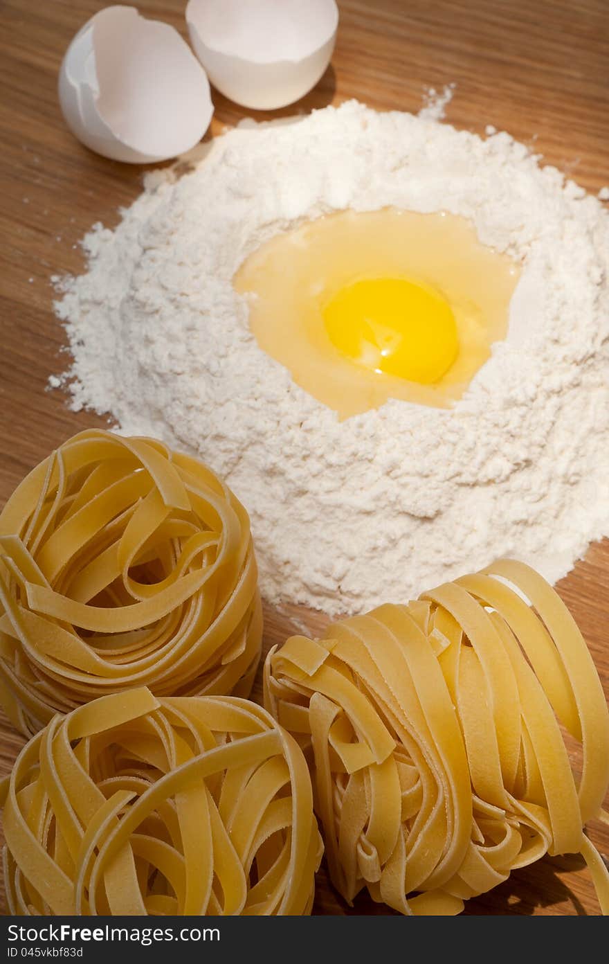 Flour with yolk and macaroni on the wood table