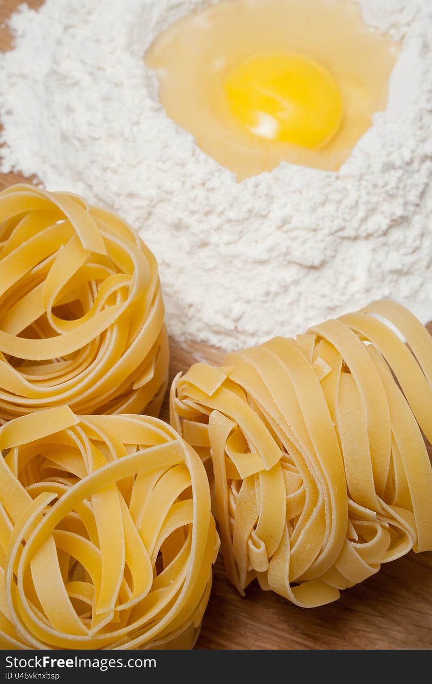 Flour with yolk and macaroni on the wood table