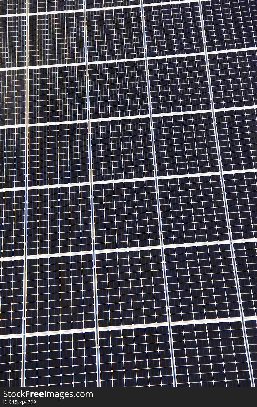 A top down close up view of the grid pattern and surface of rooftop solar panels. A top down close up view of the grid pattern and surface of rooftop solar panels.