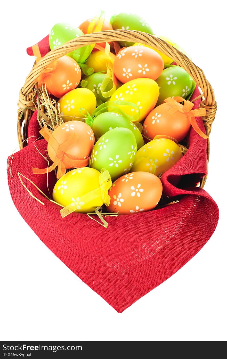 Painted easter eggs in basket isolated on white background