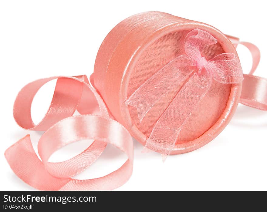 Pink gift box against a background of silk ribbons