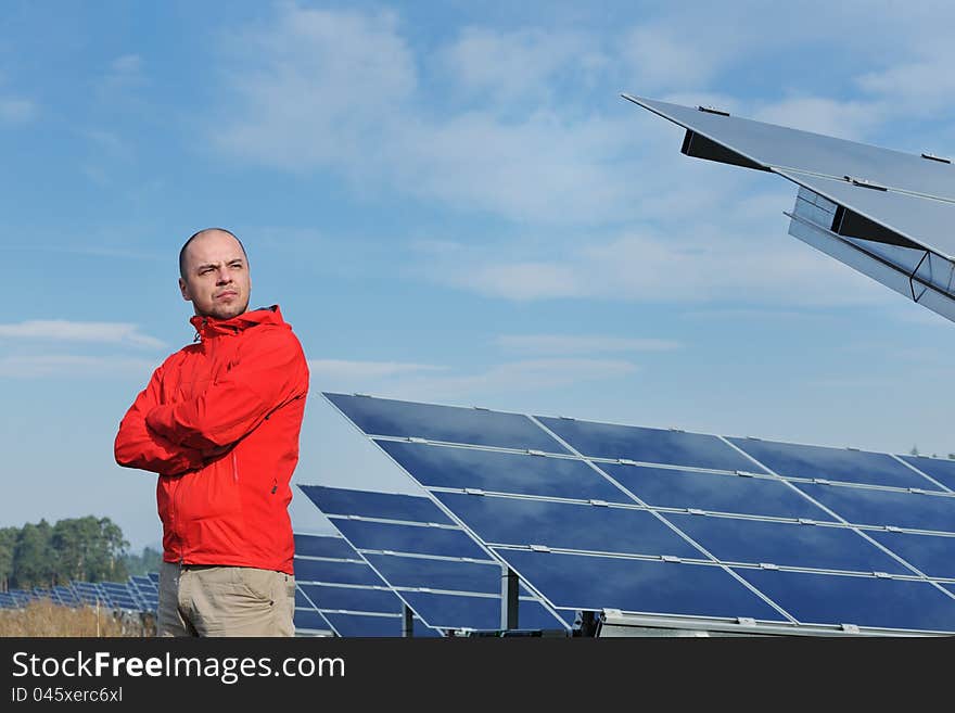 Male engineer at work place, solar panels plant industy in background. Male engineer at work place, solar panels plant industy in background