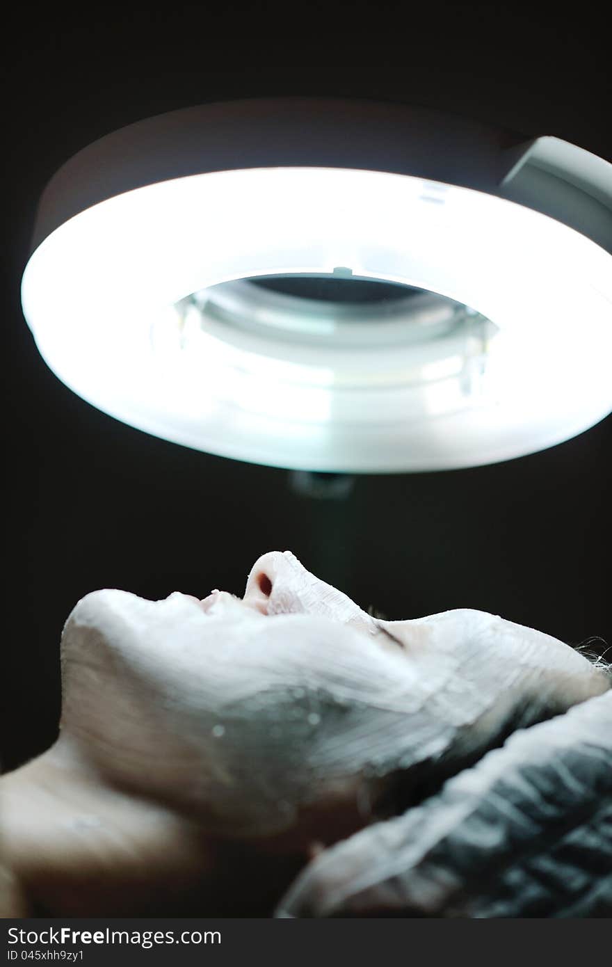 Woman with facial mask in cosmetic studio