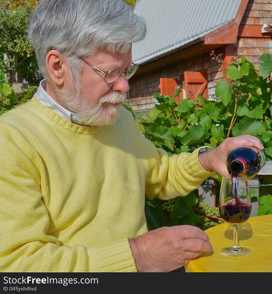 Senior male pouring a glass of red wine