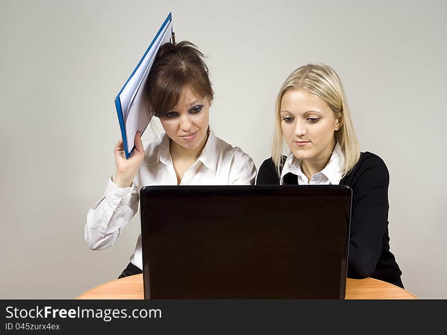 Beautiful girls dissatisfaction with the look of the laptop keep the documents at the table