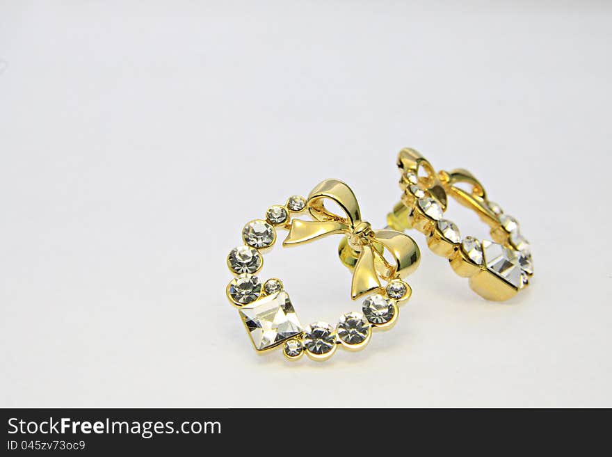 Gold earrings on the white background. Gold earrings on the white background