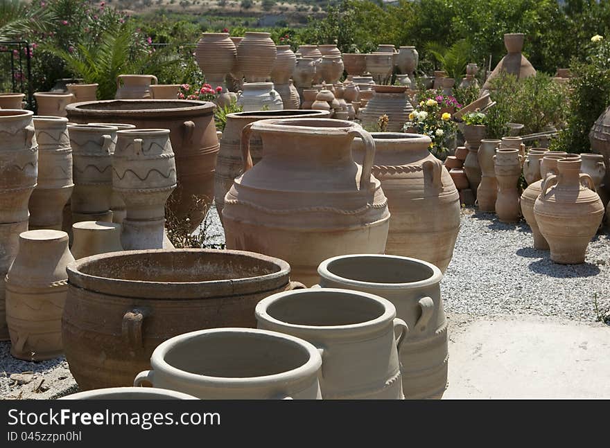 Various clay  pots stacked in an open-air market.