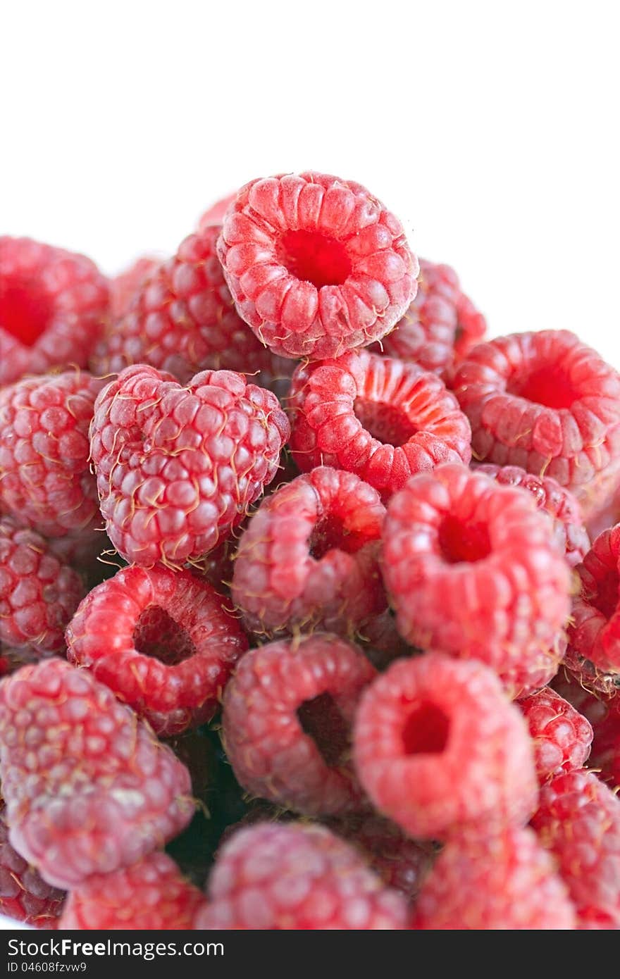 Bowl of raspberries on wooden table close up