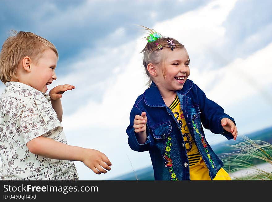 A Little Girl And Boy Play And Cheered Outdoors