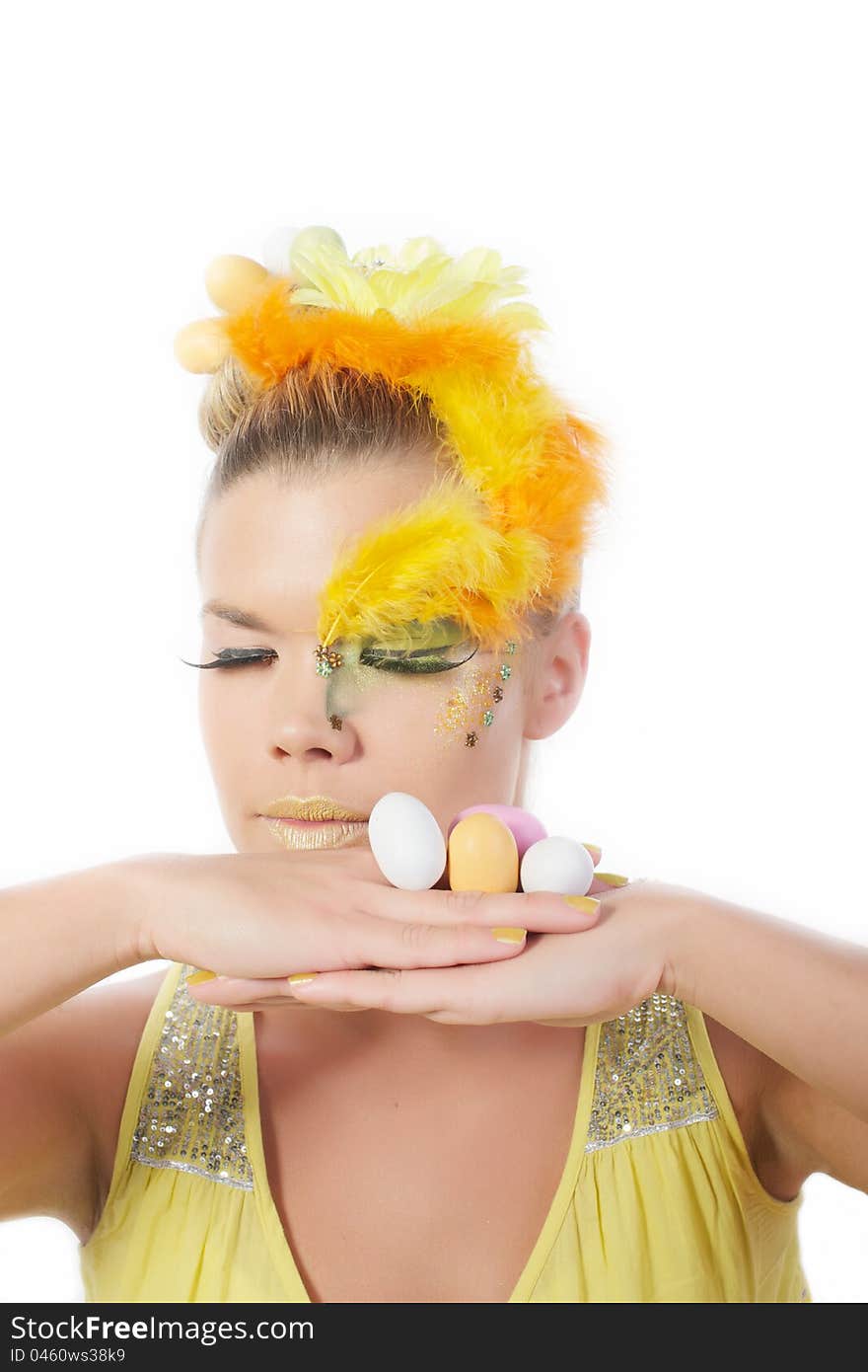 Picture of an easter girl dressed in yellow, with eggs in her hair and hands, on a white, isolated background