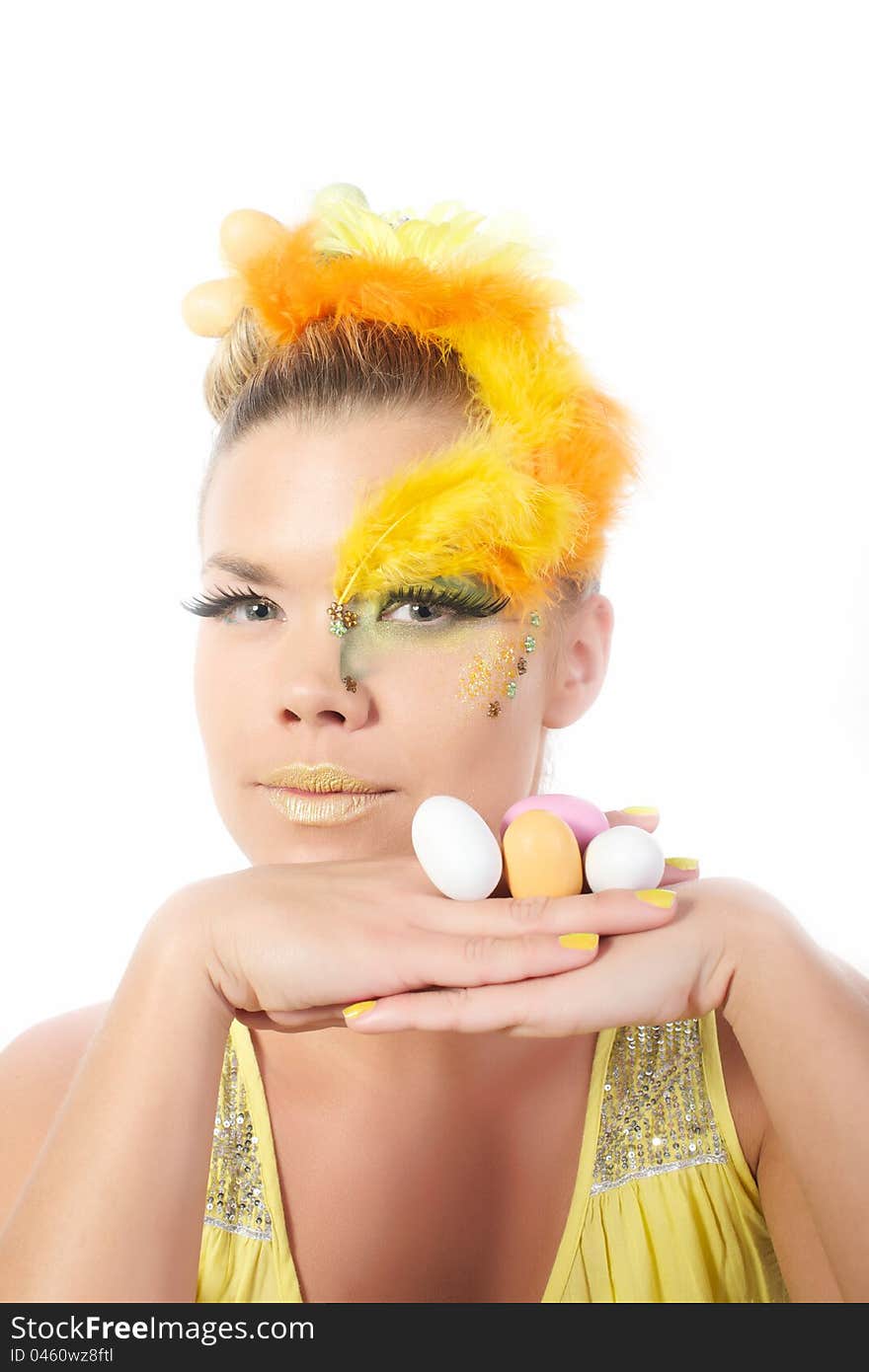 Picture of an easter girl dressed in yellow, with eggs in her hair and hands, on a white, isolated background