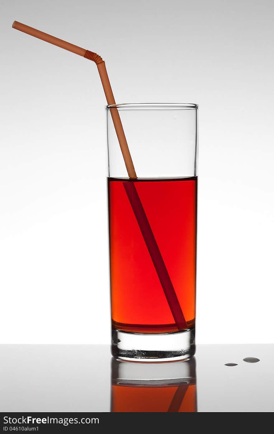 Glass of red fruit juice on white background