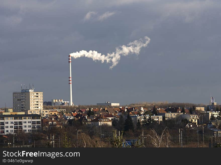 Prague industrial chimney, the smoke from the chimney on a gray background, part of the city with a smoking chimney, the city of Prague with a gray sky on a sunny day, the industry in Prague