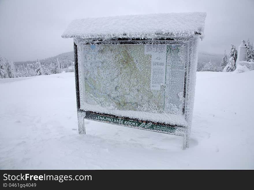 Frozen snow covered information board with touristic map in the moutains. Frozen snow covered information board with touristic map in the moutains