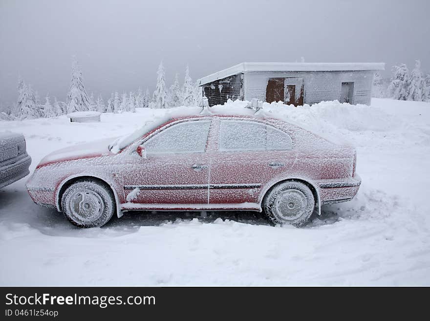 Snow cowered red car