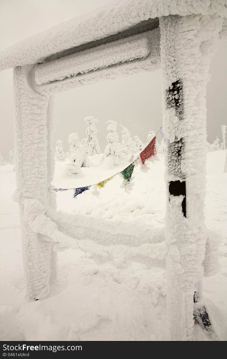 Flags in a wooden structure, colored flags on the big rain, the approximate location in the mountains in winter, overcast winter day in the Eagle Mountains, the highest point of the Eagle Mountains. Flags in a wooden structure, colored flags on the big rain, the approximate location in the mountains in winter, overcast winter day in the Eagle Mountains, the highest point of the Eagle Mountains