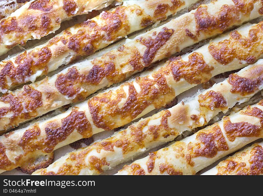 Baked baton texture with cheese crust in close view. Baked baton texture with cheese crust in close view