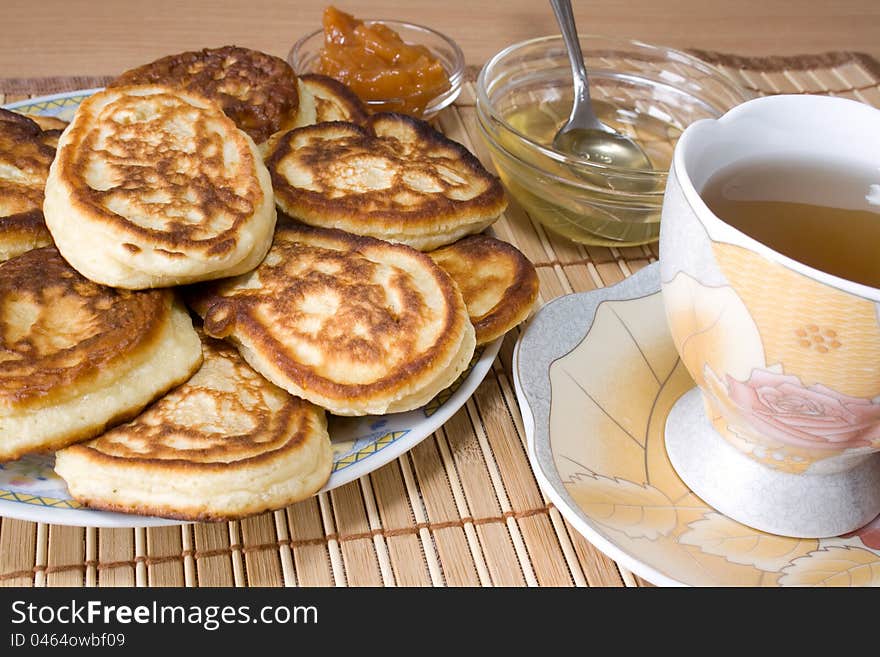 Pancakes, a cup of hot tea, honey and jam for a tasty breakfast. Pancakes, a cup of hot tea, honey and jam for a tasty breakfast