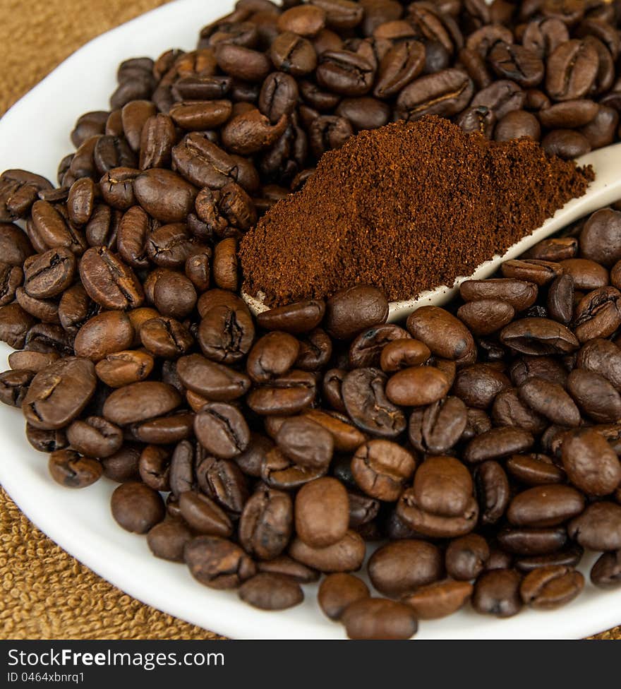 Coffee Beans And Ground Coffee In A Spoon.