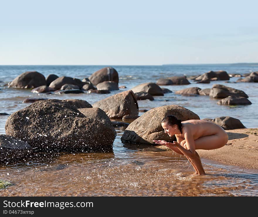 Nude woman playing with water