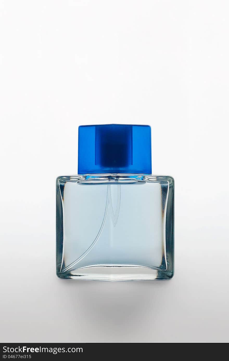 Studio shot of a perfume bottle with blue cap on white matte background with shadow