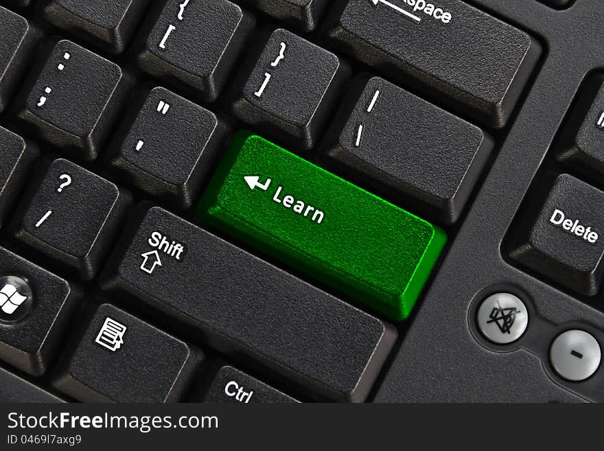 Close up of black pc keyboard, focus on green learn key, education concept