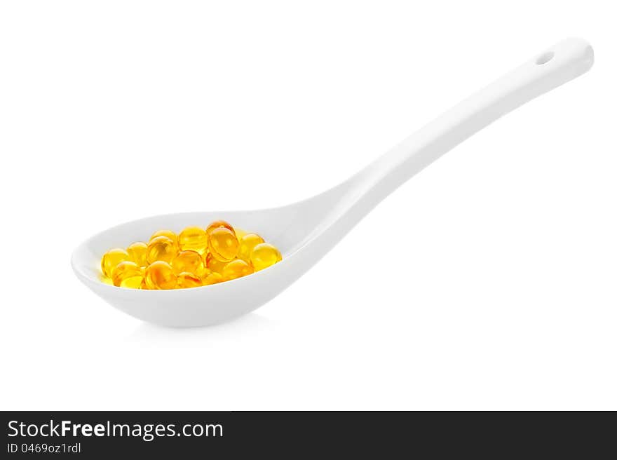 Pharmacy. Vitamin pills in spoon on white background