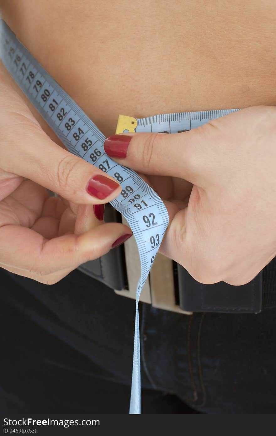 The woman in black jeans of measurement of a figure on a white background.