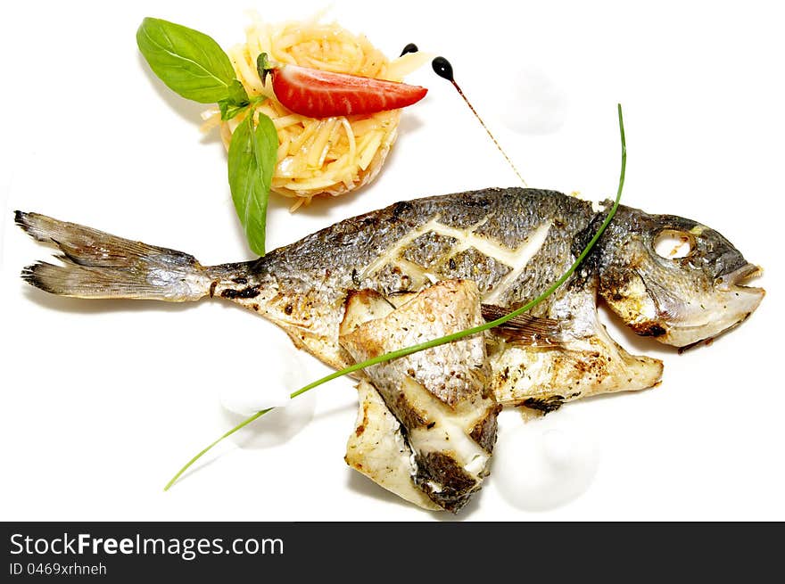 Baked fish with vegetables on a white plate