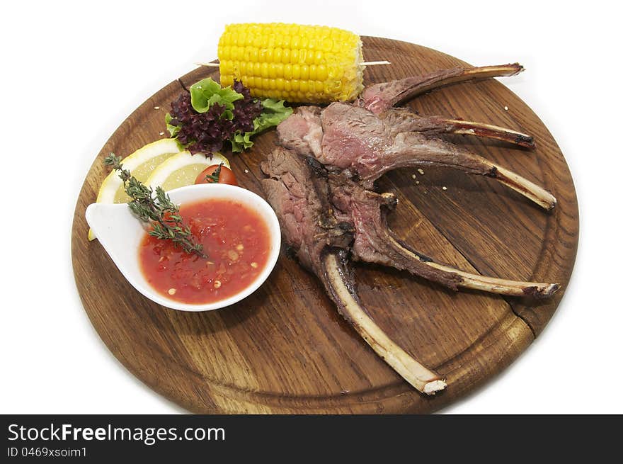 Rib roast on the plate with the sauce and corn. Rib roast on the plate with the sauce and corn